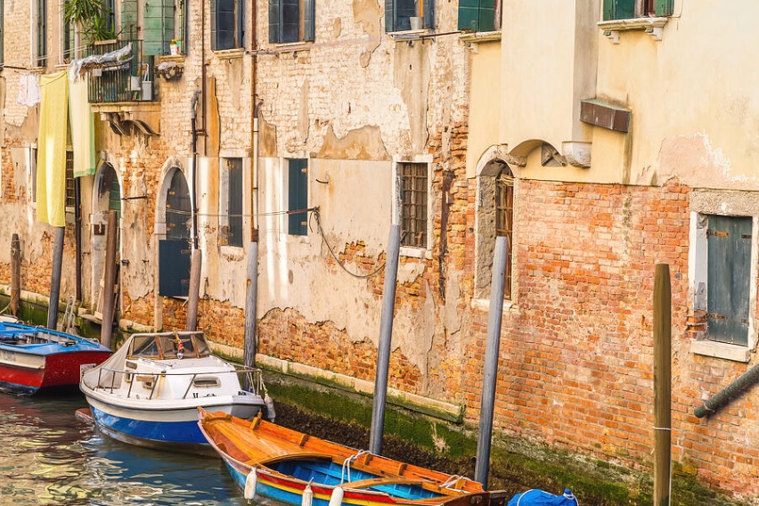 View typical canal Venice with boats mooring near ancient buildings capturing channel waterway historic architecture traditional Venetian tourism water scenic Veneto