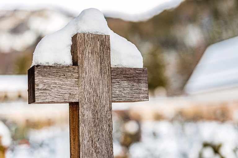 Wooden Cross Snow Catholic Cemetery Winter Dolomites Photography! Standing wooden cross covered by snow in mountain cemetery at Ortisei in Italian Dolomites Alps. This religious photograph captures simple wooden crucifix blanketed in white snow representing Catholic spirituality and faith in high-altitude alpine setting.